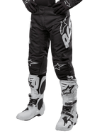 Alpinestars 2024 Racer Hana Pants, motorcross broek, zwart met witte Alpinestars logo's, sportieve pasvorm, gedragen met witte motorlaarzen en zwarte handschoenen, off-road motoruitrusting