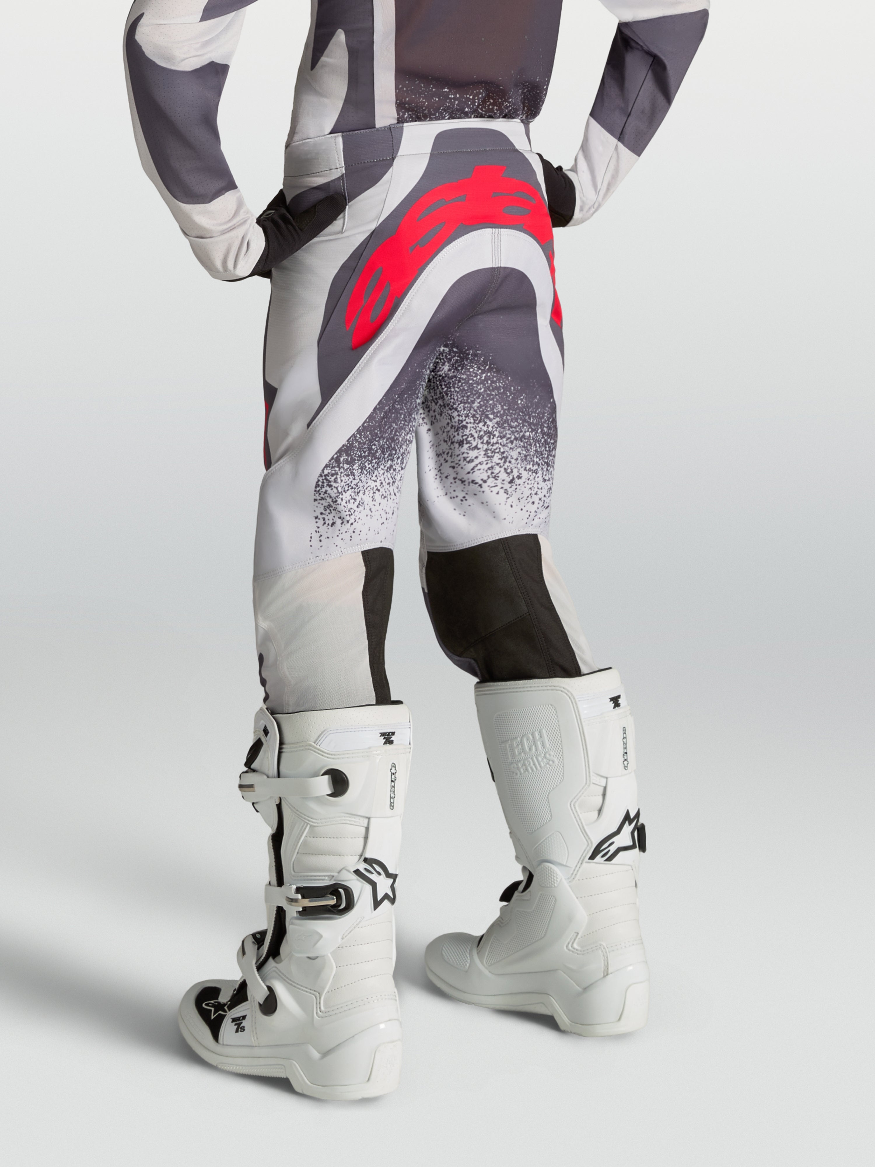 Alpinestars Jeugd Supertech Swan broek, motocrossbroek in grijs en lila met rood logo, achteraanzicht op model.