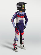 Alpinestars Jeugd Supertech Dyna broek, motorcross-racebroek voor kinderen, paars en roze fluo, stretch rip-stop textiel, gedragen door jonge rijder met volledige race-uitrusting.