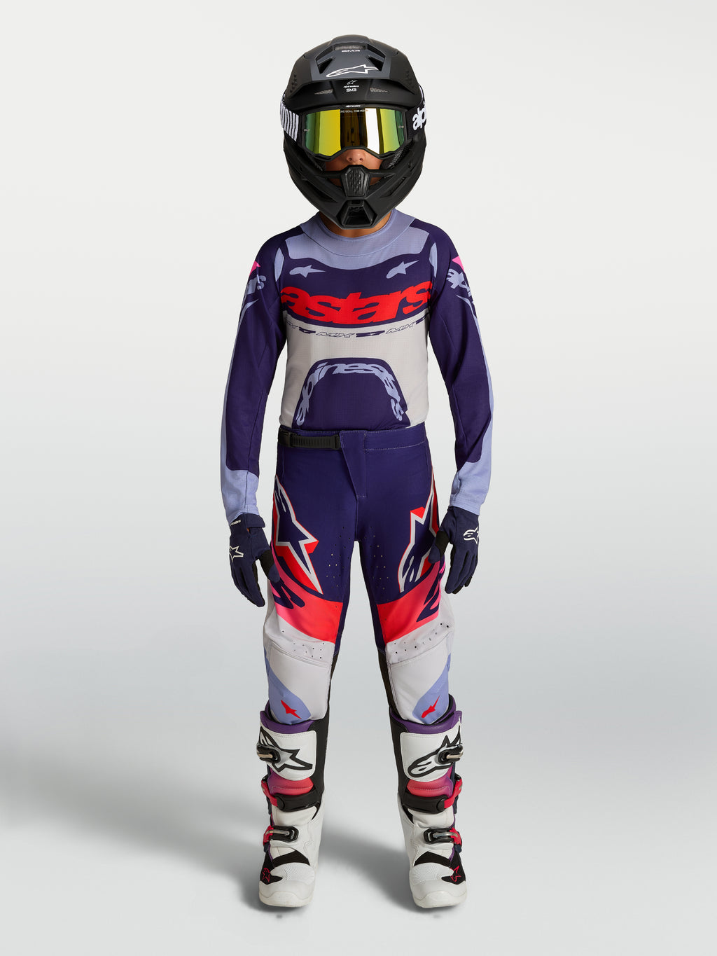 Alpinestars jeugd Supertech Dyna motorcrossbroek, paars en roze fluo, gedragen door model voor off-road racing.