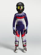 Alpinestars jeugd Supertech Dyna motorcrossbroek, paars en roze fluo, gedragen door model voor off-road racing.
