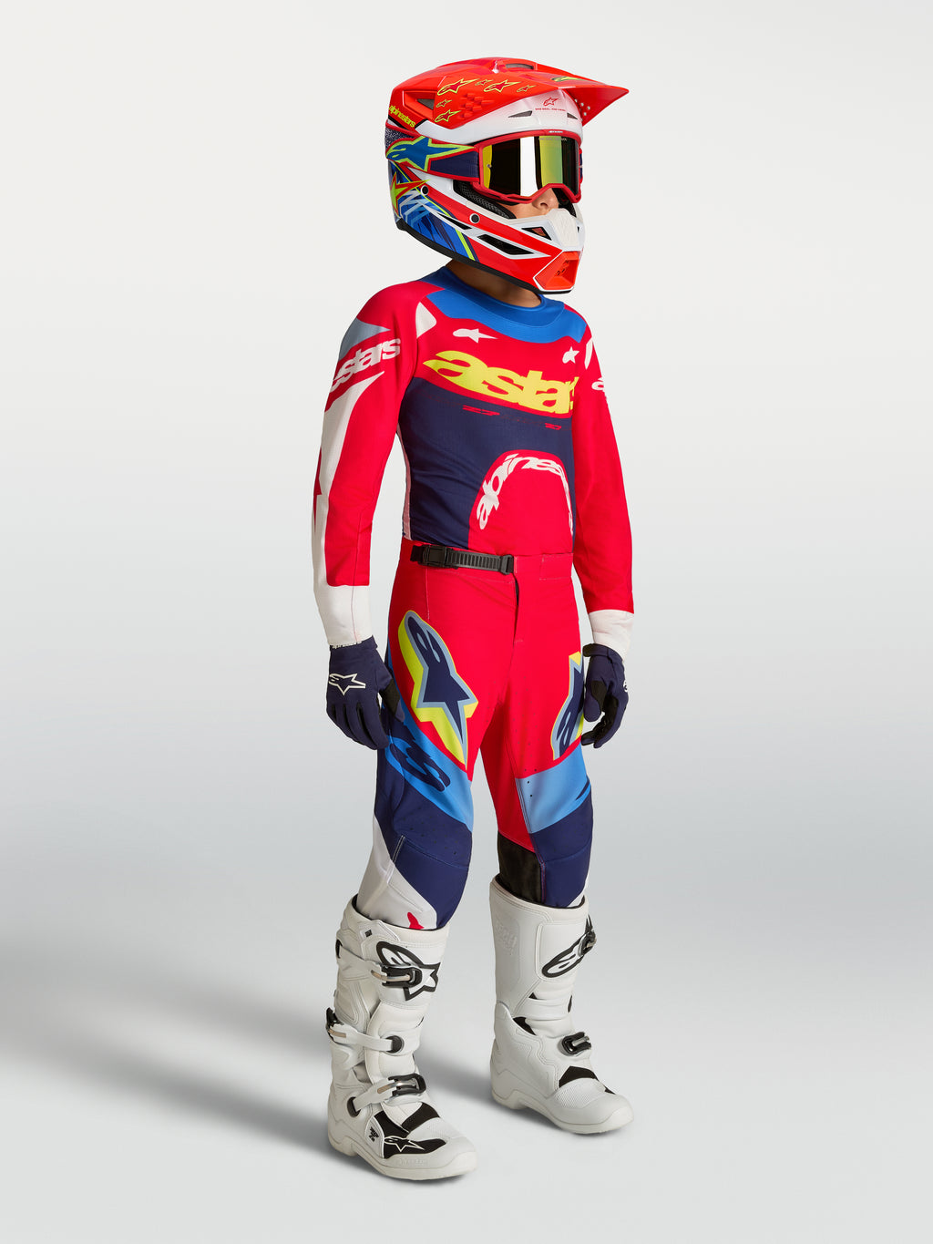 Alpinestars Jeugd Supertech Dyna broek, rood en marineblauw, motocrossbroek op model met jersey, helm en laarzen.
