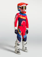 Alpinestars Jeugd Supertech Dyna broek, rood en marineblauw, motocrossbroek op model met jersey, helm en laarzen.
