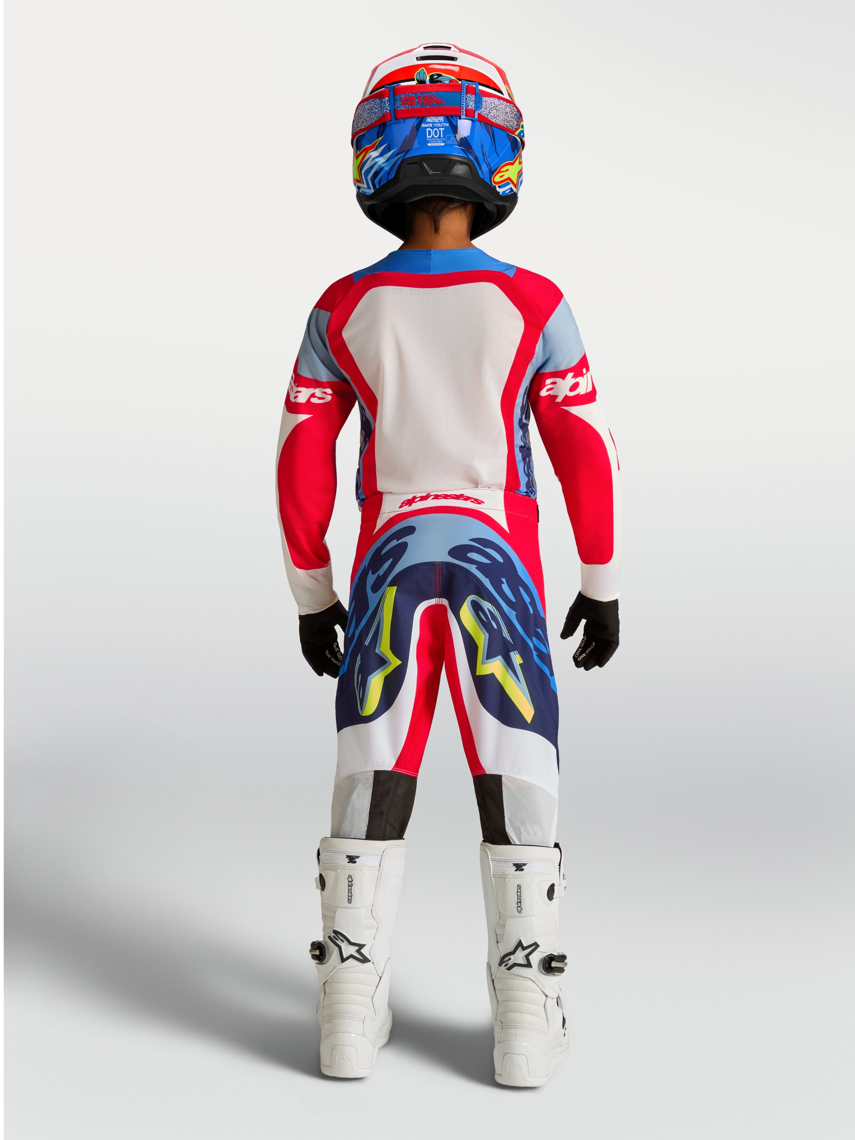 Alpinestars Jeugd Supertech Dyna broek, rood en donkerblauw motocross-tenue voor jonge rijders, achteraanzicht op model.