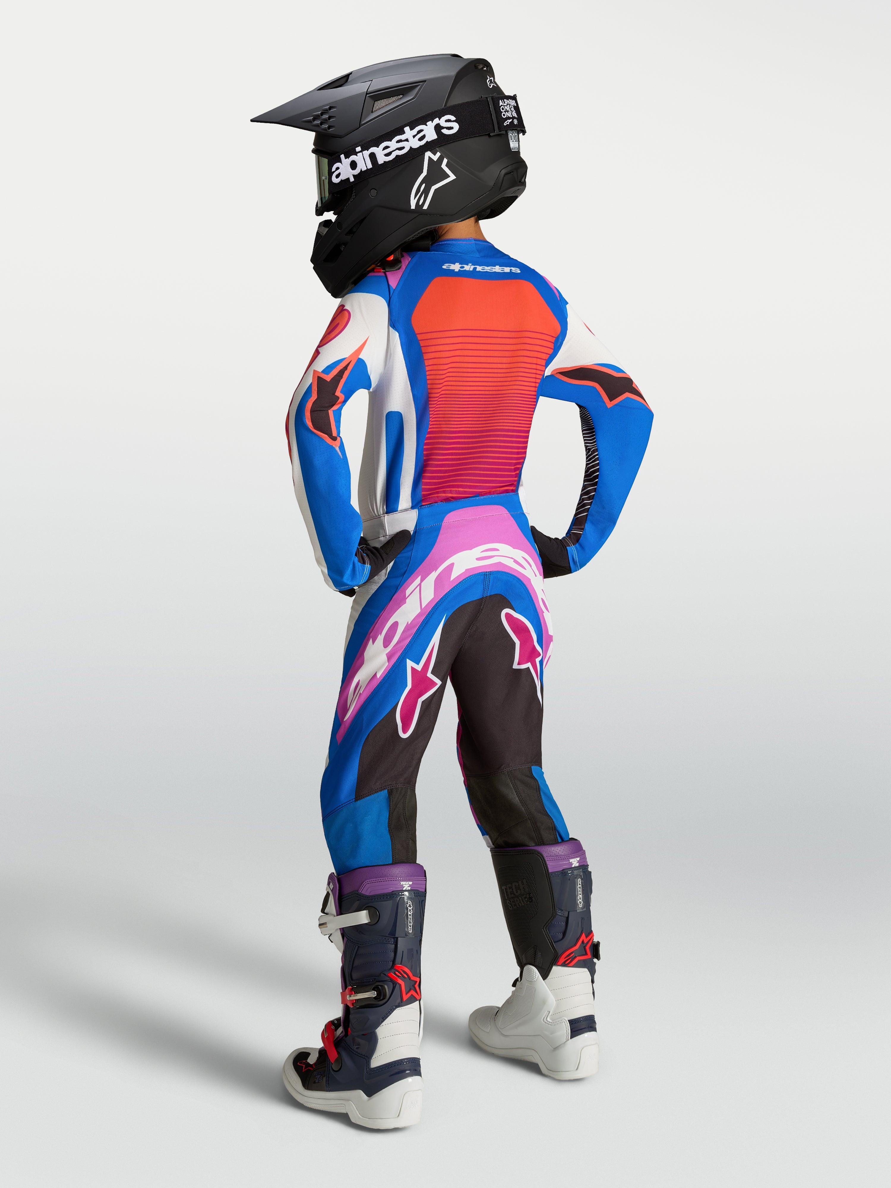 Alpinestars Jeugd Supertech Maven broek, motocross-racebroek in wit en koraal, van achteren gezien op een model.