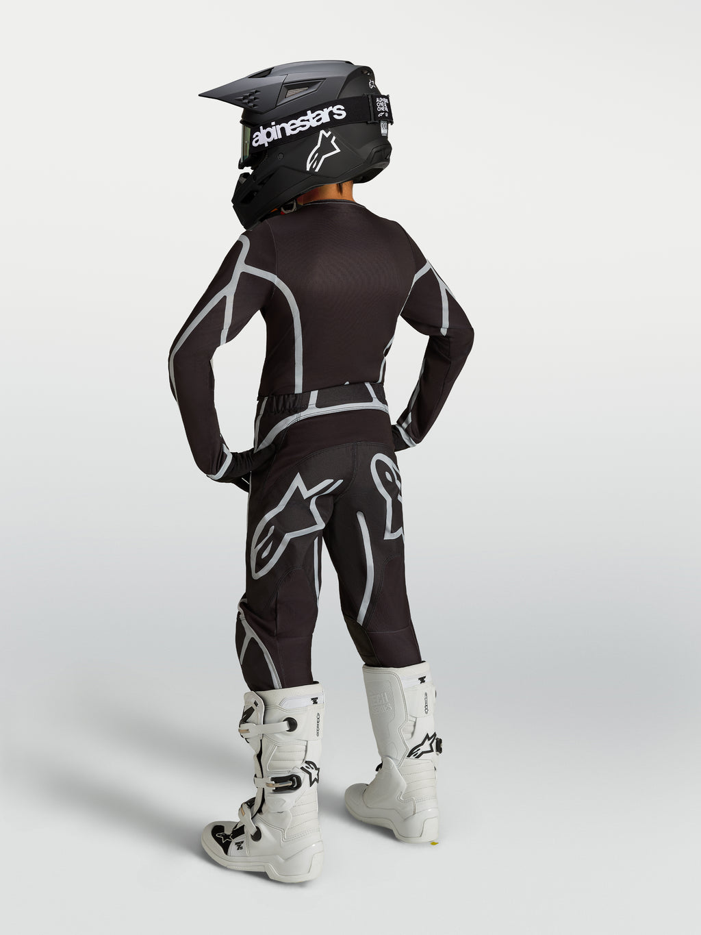 Alpinestars Youth Fluid Apex V2 Pants in Black and Silver, shown from the back as part of a full motocross racing kit.