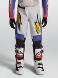 Alpinestars jeugd Fluid Drag broek, witte en blauwe motorcrossbroek met gouden graphics en ergonomische pasvorm.