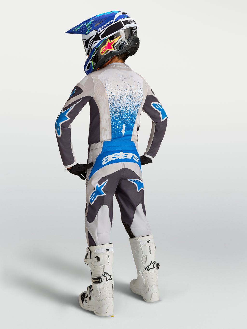 Alpinestars Jeugd Fluid Drag broek, grijze en blauwe motorcrossbroek, textielconstructie, achteraanzicht jonge rijder.