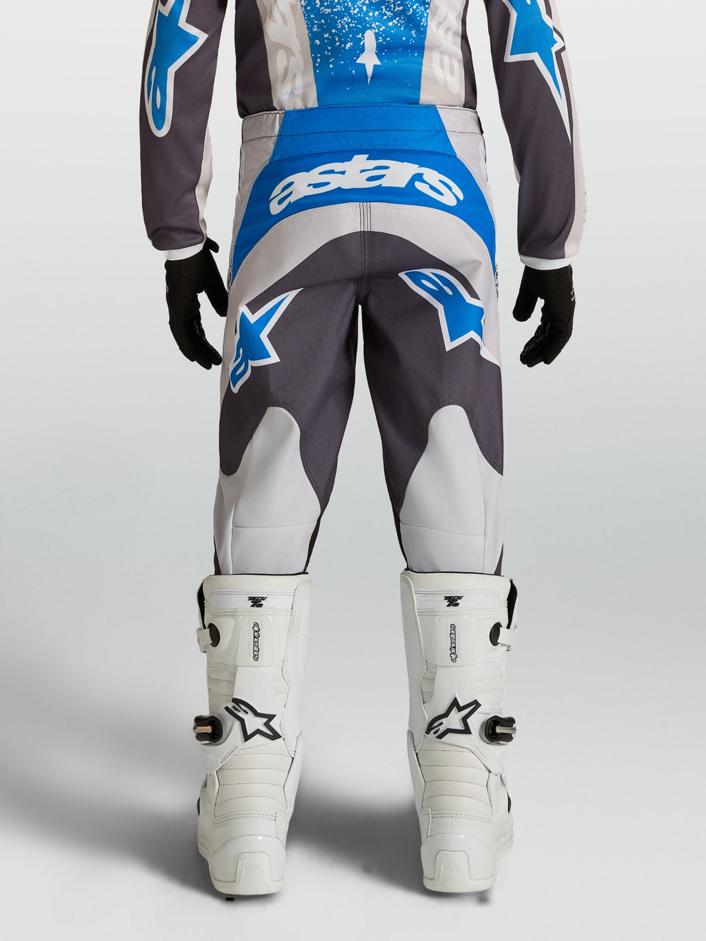 Alpinestars Jeugd Fluid Drag broek in blauw en grijs, duurzame motocrossbroek met voorgevormde pasvorm, achteraanzicht.