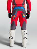Alpinestars Jeugd Fluid Hunt broek, rood en grijze motocrossbroek met blauwe ster-graphics en 600D-zitvlak, achteraanzicht.