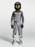 Alpinestars Jeugd Fluid Amber Broek 2027, grijze en zandkleurige motorcrossbroek van 600D textiel voor jonge off-road rijders.