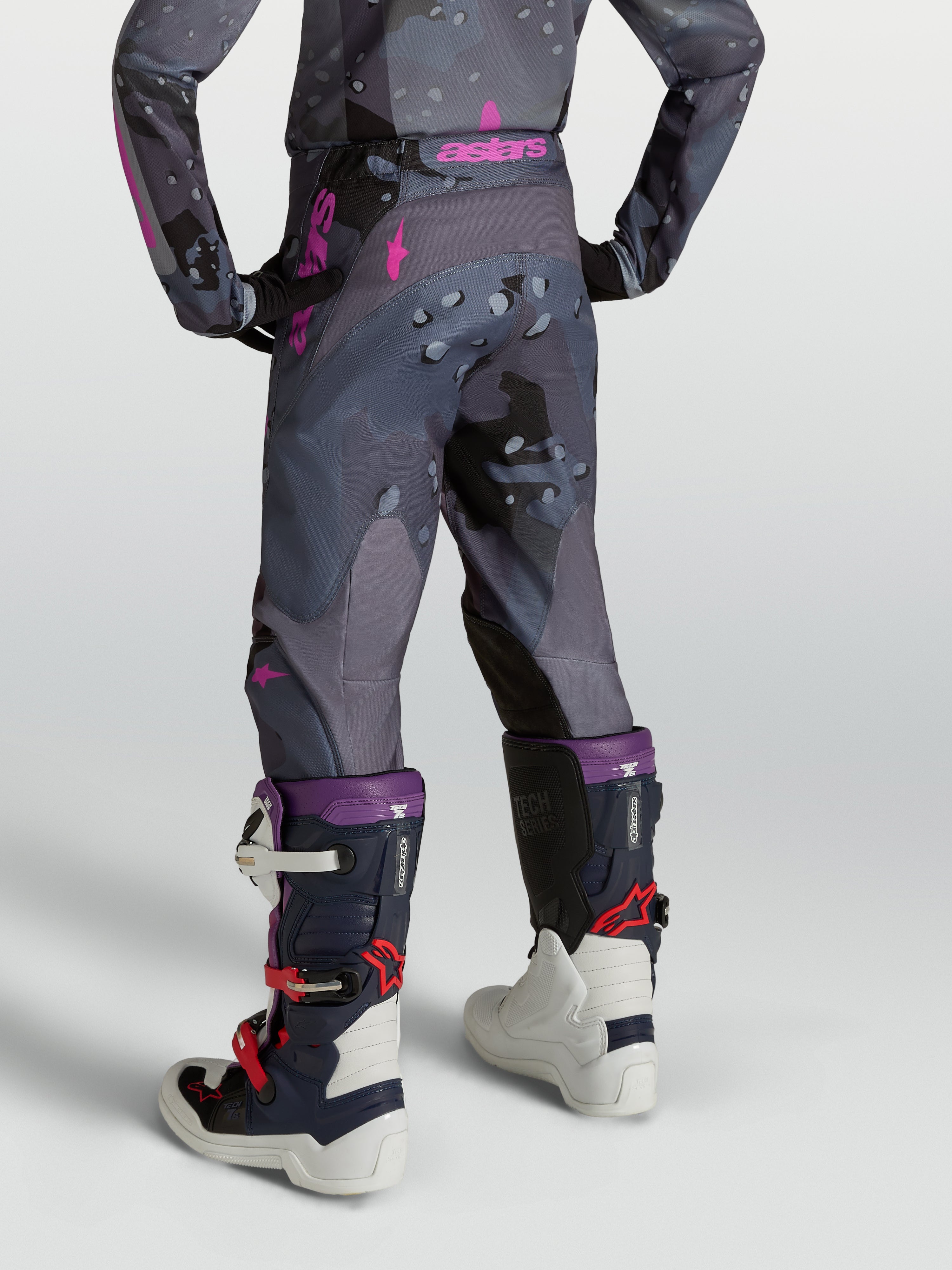 Alpinestars Jeugd Fluid Lone motocrossbroek, grijs camo en paars, ergonomische 3D-pasvorm, achteraanzicht op model.