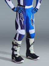 Alpinestars 2026 Youth Fluid Portl Pants, Motocross Pants, UCLA Blue and White, worn with matching blue gloves and black and white boots, featuring bold white logos on the thighs, ergonomic sport-fit design for off-road racing.