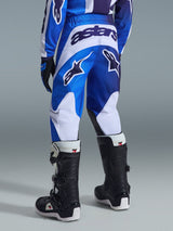 Alpinestars 2026 Youth Fluid Portl Pants, Motocross Pants, Ucla Blue and White, rear view showing bold 'astars' branding and logos, worn with black and white boots and matching jersey, durable athletic fit for young off-road riders