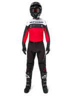 Motocross rider wearing the Alpinestars Pro-Dura Jersey in Black, Bright Red, and White, paired with black pants, black boots, and a black helmet, complete off-road racing gear.