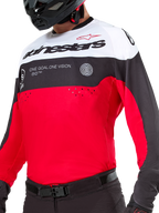 Alpinestars Pro-Dura Jersey, Motocross and Enduro Jersey, Black Bright Red and White, featuring 'ONE GOAL. ONE VISION.' graphic and laser perforations on the chest, worn with black motocross pants and helmet.