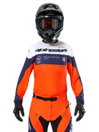 Alpinestars Pro-Dura Jersey, motorcross shirt, marineblauw, fel oranje en wit, gedragen met een zwarte helm en handschoenen, voorzien van lasergeperforeerde ventilatiezones, opvallende branding en 'ONE GOAL. ONE VISION.' graphic op de borst