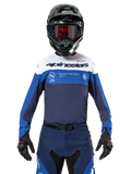 Alpinestars Pro-Dura Jersey, motocross- en enduroshirt, marineblauw, helderblauw en wit, gedragen met bijpassende marineblauwe broek, zwarte handschoenen en helm, voorzien van merklogo op de borst en lasergesneden ventilatie voor off-road motorraces