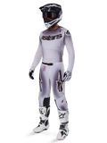 Alpinestars 2025 Supertech Maker Gear Set, complete motorcross outfit, wit en grijs kleurverloop met zwarte branding en rode accenten, inclusief helm met crossbril, jersey, broek, witte laarzen en handschoenen, strak prestatiegericht ontwerp voor off-road racen