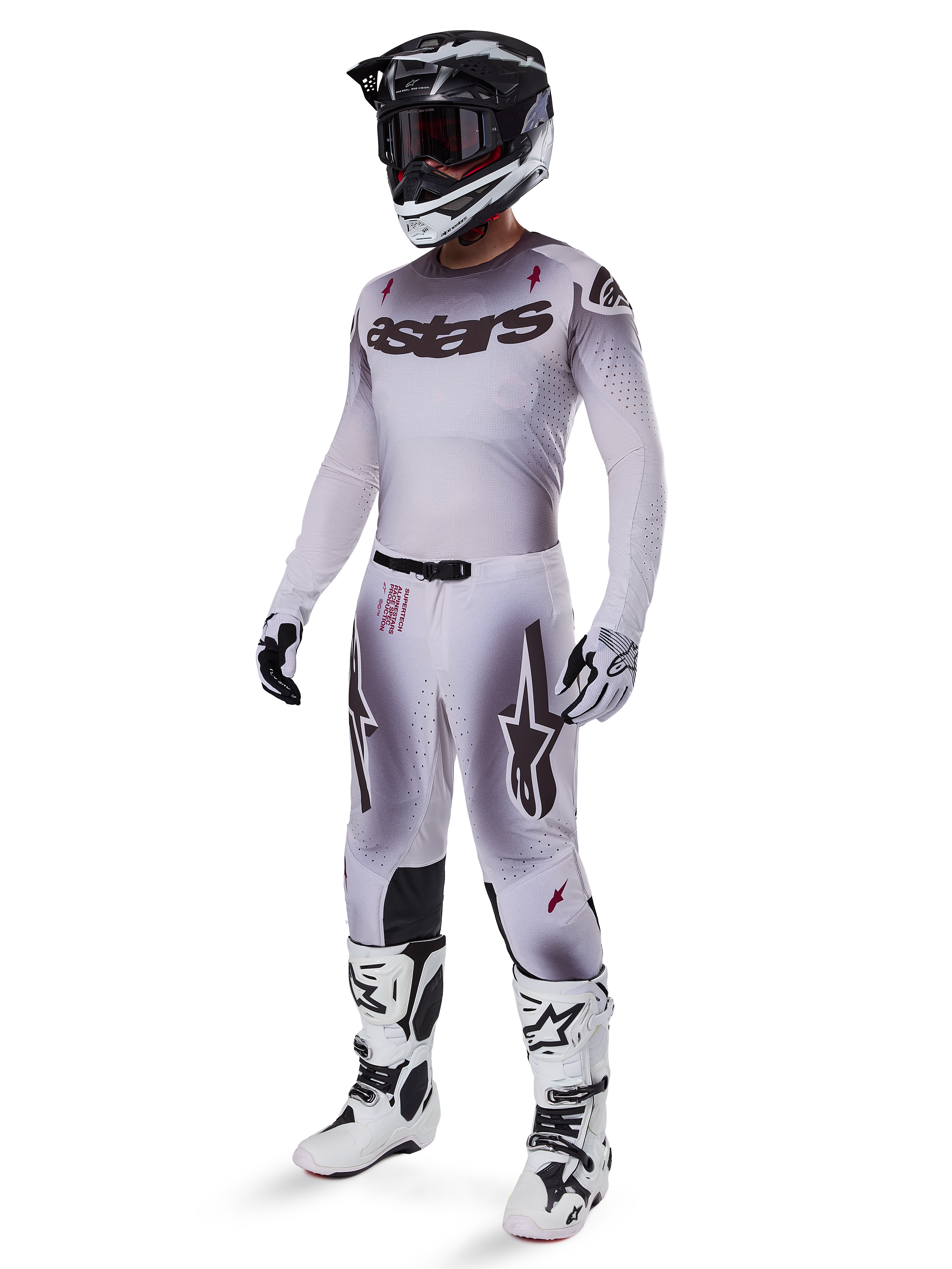 Alpinestars 2025 Supertech Maker Gear Set, complete motorcross outfit, wit en grijs kleurverloop met zwarte branding en rode accenten, inclusief helm met crossbril, jersey, broek, witte laarzen en handschoenen, strak prestatiegericht ontwerp voor off-road racen