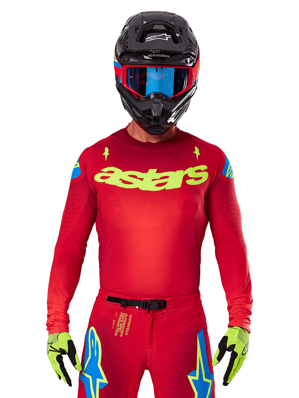 Alpinestars 2025 Supertech Maker Jersey in Bright Red Yellow Fluo, met geel 'astars' logo op de borst en blauwe sterrendesigns op de schouders, gedragen met bijpassende broek, zwarte helm, blauwe bril en gele handschoenen, professionele motorcross racekleding