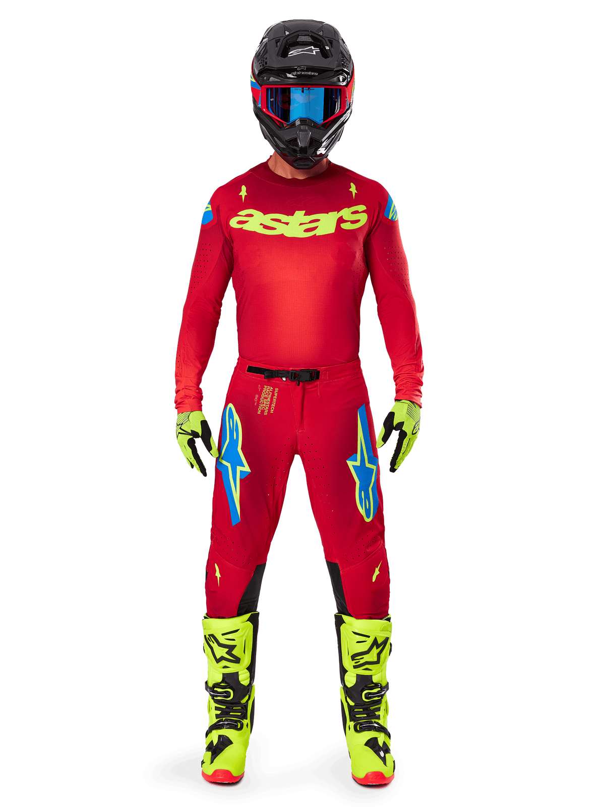 Motocrossrijder in een complete Alpinestars 2025 Supertech Maker Gear Set, helderrood jersey met gele fluo 'astars' branding, bijpassende rode broek met blauwe accenten, zwarte helm met blauwe bril, felgele fluo laarzen en handschoenen, gecoördineerde outfit voor off-road racing