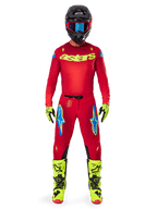 Motocrossrijder in een complete Alpinestars 2025 Supertech Maker Gear Set, helderrood jersey met gele fluo 'astars' branding, bijpassende rode broek met blauwe accenten, zwarte helm met blauwe bril, felgele fluo laarzen en handschoenen, gecoördineerde outfit voor off-road racing