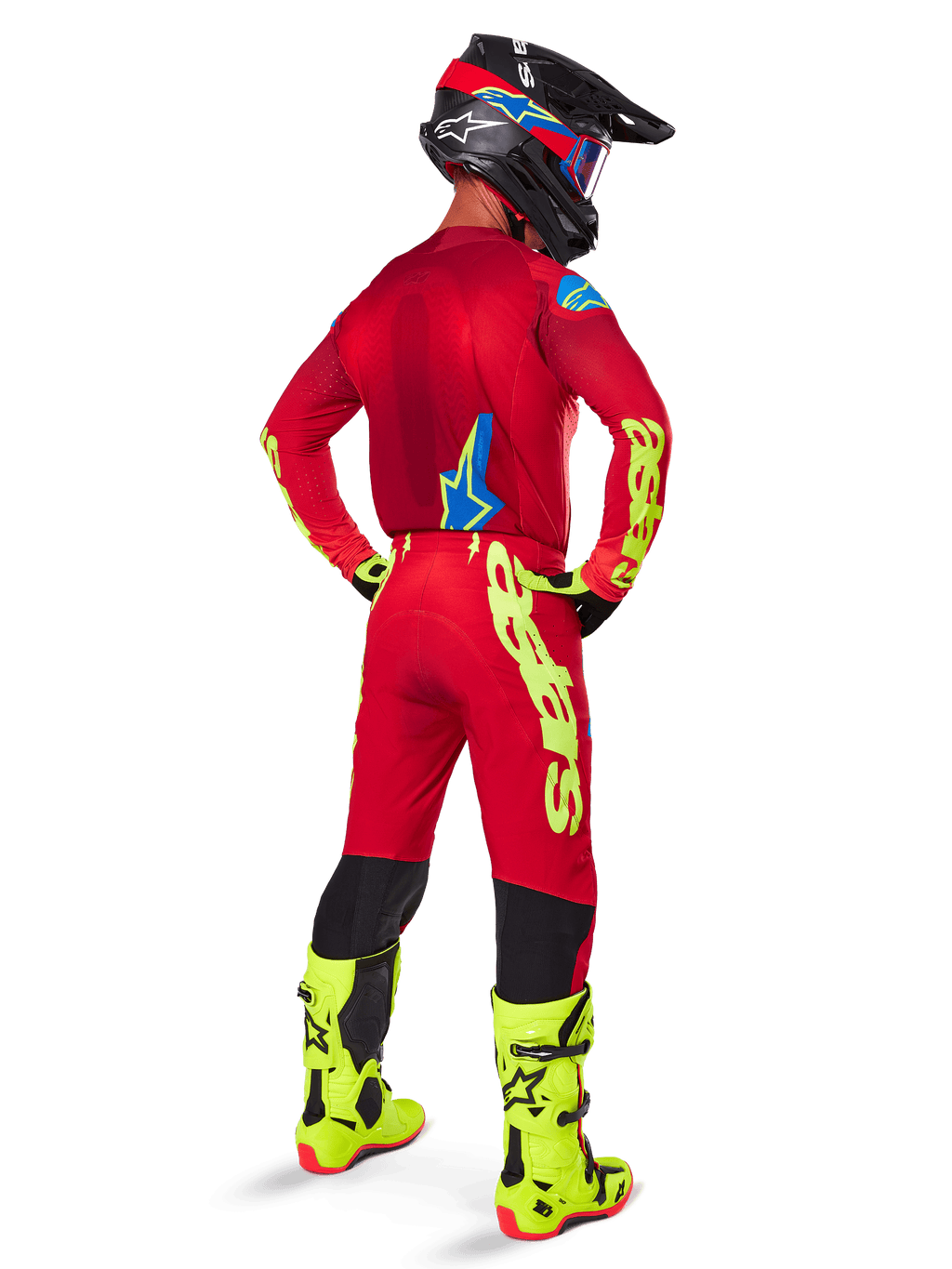 Motocrossrijder van achteren gezien in de Alpinestars 2025 Supertech Maker Gear Set, helderrood jersey met fluogele branding, bijpassende rode broek met gele accenten, zwarte helm met rode en blauwe details, fluogele laarzen, gecoördineerde professionele race-outfit voor off-road prestaties.