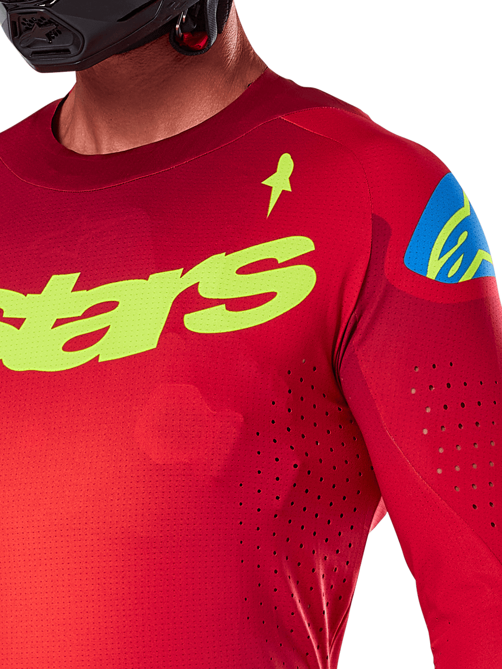 Alpinestars 2025 Supertech Maker Jersey, motocross jersey, felrood en fluoriserend geel, close-up weergave met lasergesneden perforaties, geel Alpinestars-logo op de borst, blauw schouderdetail, ademende stretch mesh-stof