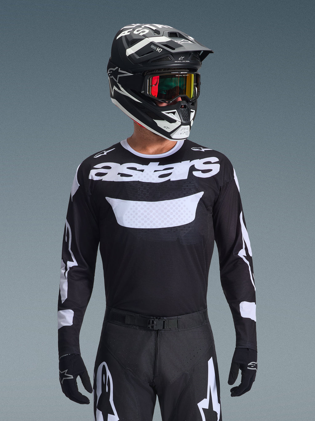 Alpinestars 2026 Racer Air Riway Jersey, zwart-wit motorcross jersey met 'astars' branding, gedragen door een rijder met bijpassende zwarte helm, crossbril en broek, voorzien van ademende mesh-panelen voor off-road racen.