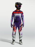 Alpinestars Supertech Dyna jersey, heren-motocrossjersey in lichtpaars en dieppaars met fluo roze accenten, gedragen met een bijpassende broek en witte motorlaarzen.