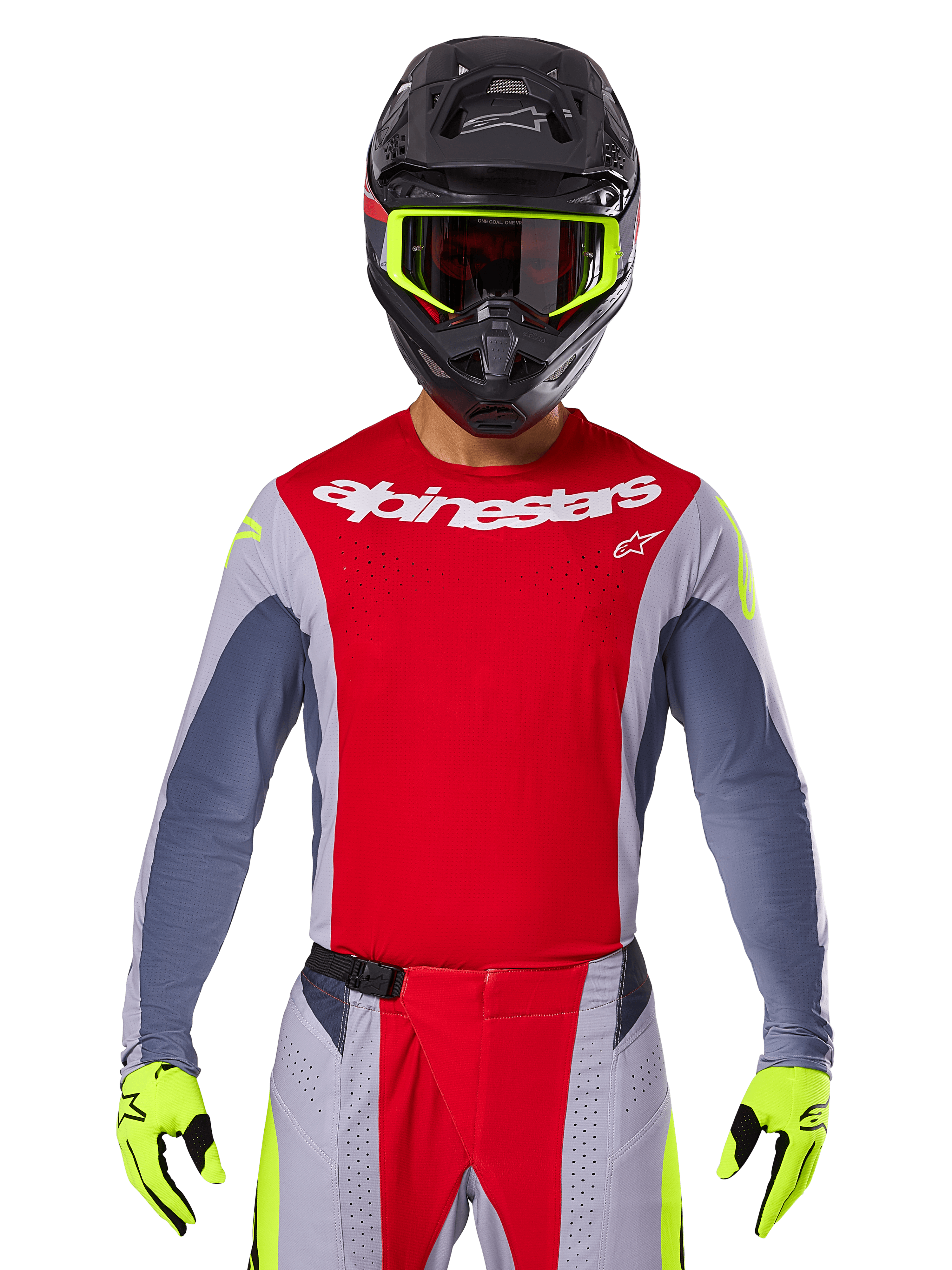 Alpinestars motorcrosser draagt 2025 Techstar Melt Jersey en bijpassende broek, felrood en grijs met witte branding, zwarte helm met neongele crossbril, bijpassende neongele handschoenen, geventileerde prestatiegerichte uitrusting voor off-road racen