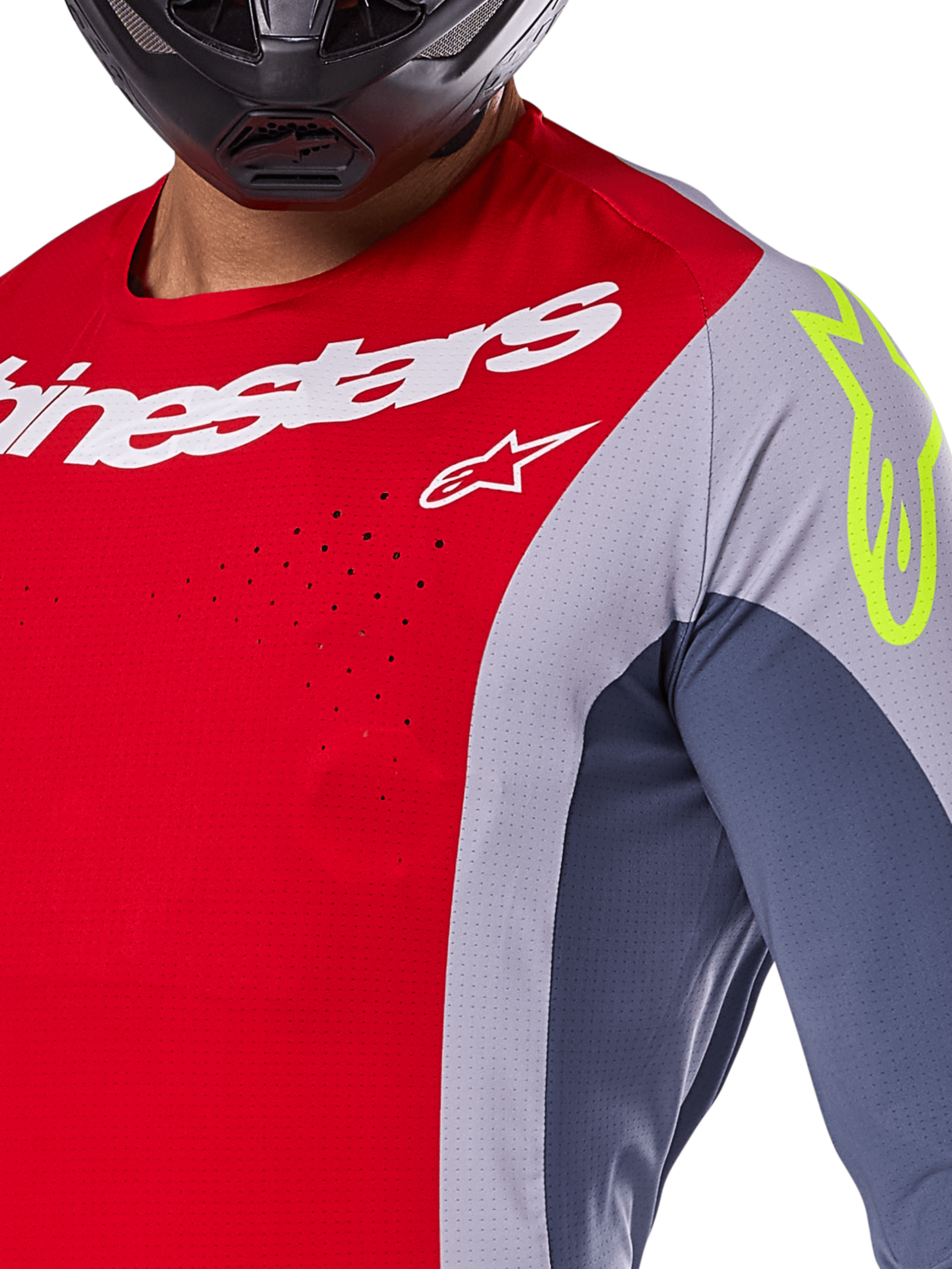 Alpinestars 2025 Techstar Melt Jersey, motorcross jersey, felrood en grijs met donkerblauwe panelen, met witte Alpinestars-branding en een neongeel logo op de schouder, close-up met lasergesneden ventilatieperforaties en een zwarte helm.