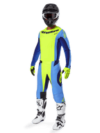 Motocrossrijder draagt Alpinestars 2025 Techstar Melt Jersey, fluorgeel en blauw, gecombineerd met bijpassende broek, zwarte helm met crossbril, gele handschoenen en wit-zwarte laarzen, complete gecoördineerde uitrusting voor off-road racen