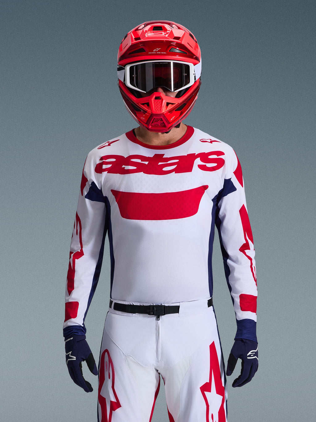 Alpinestars 2026 Racer Riway Gear Set, Motocross rider wearing white jersey with red branding and navy blue accents, matching white pants with red graphics, red helmet with white goggles, navy blue gloves, coordinated professional off-road racing outfit.