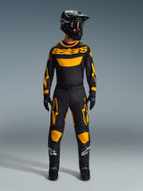 Motocross rider wearing the 2026 Racer Riway Jersey in Yellow and Black, coordinated with matching pants, black helmet, and black boots with white Alpinestars logos, full gear set for off-road racing.