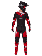 Motocrosser in Alpinestars 2025 Racer Veil kledingset, zwart en felrood jersey met wit Alpinestars-logo, bijpassende motocrossbroek, zwarte helm met rode bril en rode laarzen, complete performance-outfit voor off-road rijden