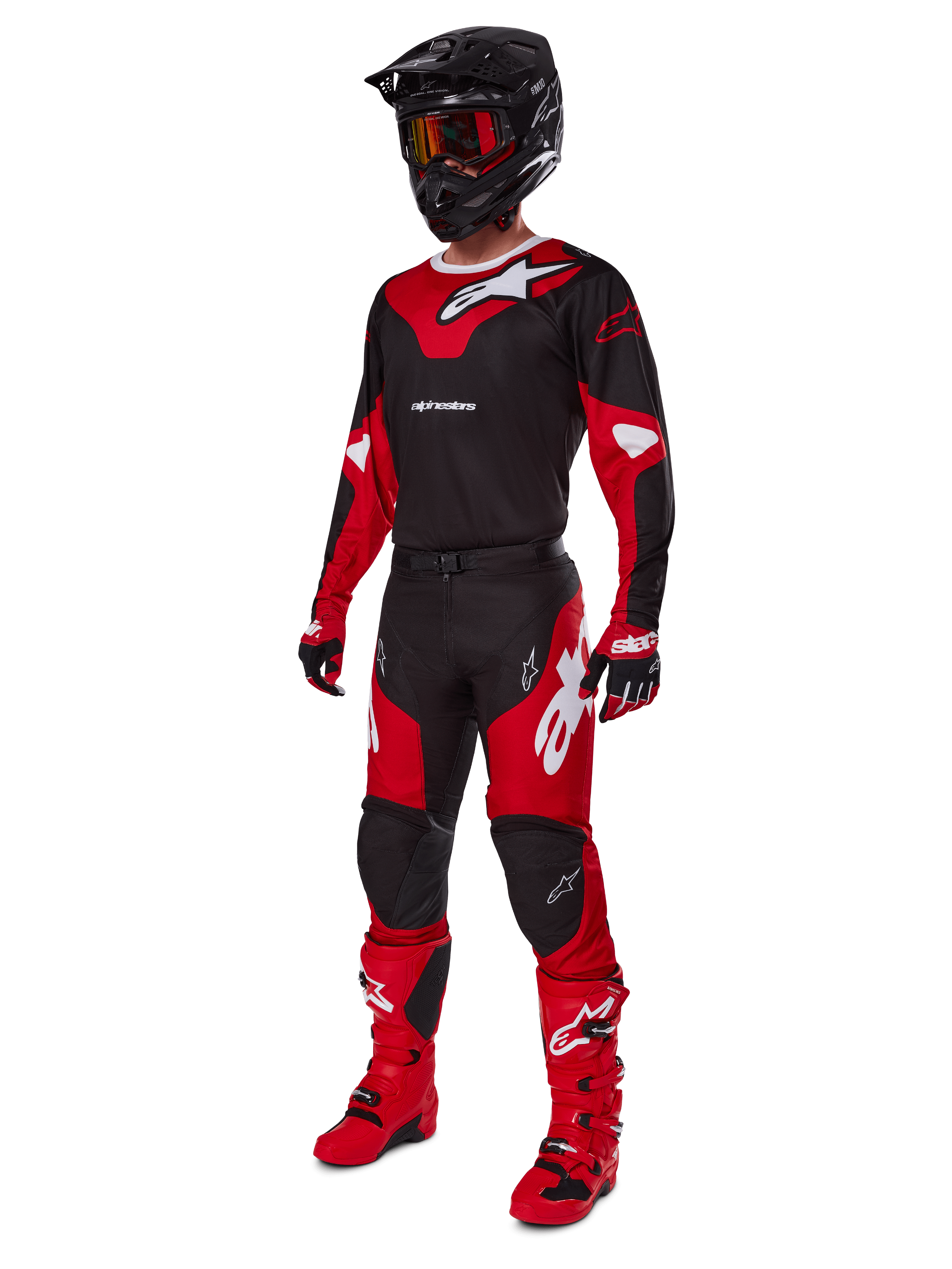 Motorcrosser in een volledige race-uitrusting met de Alpinestars 2025 Racer Veil Jersey in zwart en felrood, bijpassende broek, rode laarzen, zwarte helm met rode bril en rood-zwarte handschoenen, gecoördineerde performance-look voor off-road racen