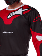 Alpinestars 2025 Racer Veil Jersey, motorcross shirt, zwart en felrood, close-up weergave met een groot wit sterlogo op een rood borstpaneel en het 'alpinestars' woordmerk, sportief ontwerp met ademend technisch materiaal voor off-road racing