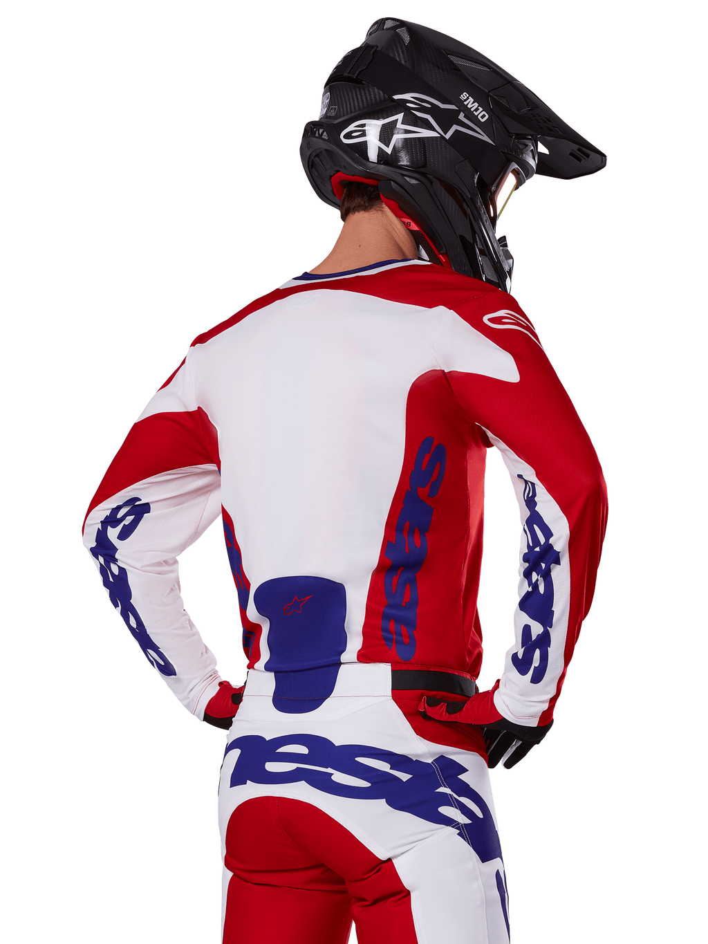 Alpinestars 2025 Racer Veil Jersey en broek, motorcross kledingset, helder rood, wit en blauw, achteraanzicht van rijder met bijpassende uitrusting en zwarte motorcrosshelm, voorzien van opvallende blauwe Alpinestars-branding, technische off-road racekleding.