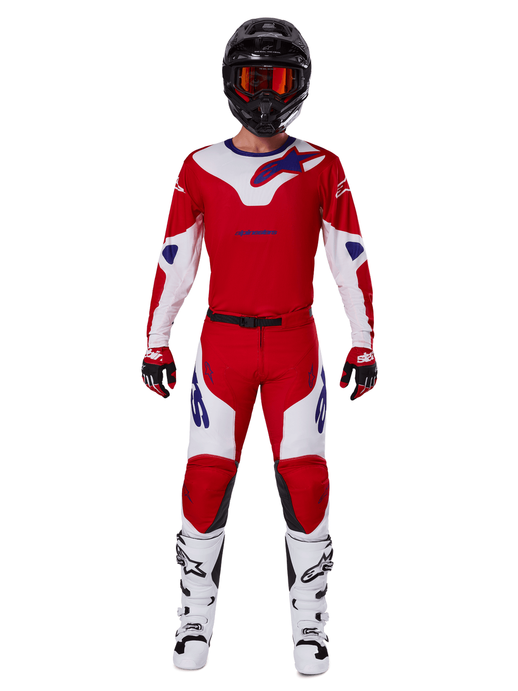 Motorcrossrijder in de Alpinestars 2025 Racer Veil Gear Set, felrood en wit jersey en broek met blauwe accenten, zwarte helm met rode bril, witte laarzen en rood-zwarte handschoenen, gecoördineerde outfit voor off-road racen
