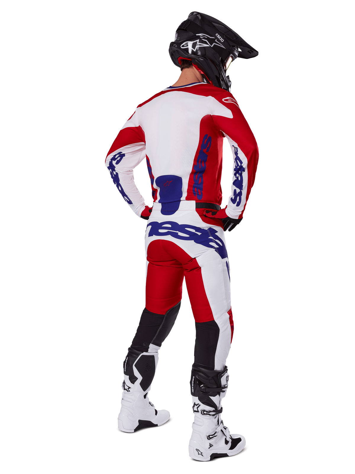 Alpinestars 2025 Racer Veil Jersey en broek, motorcross outfit van achteren gezien, rood en wit met blauwe merkdetails, zwarte helm en witte laarzen, complete kledingset voor off-road racen