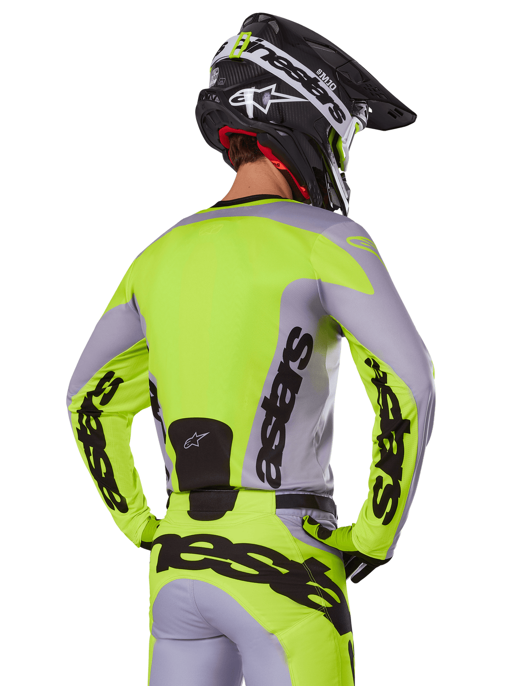 Alpinestars 2025 Racer Veil Jersey in Gray Yellow Fluo, motocross jersey van achteren gezien, met opvallende 'astars' branding op de rug en mouwen, gecombineerd met bijpassende broek en zwarte helm voor een complete race-look.