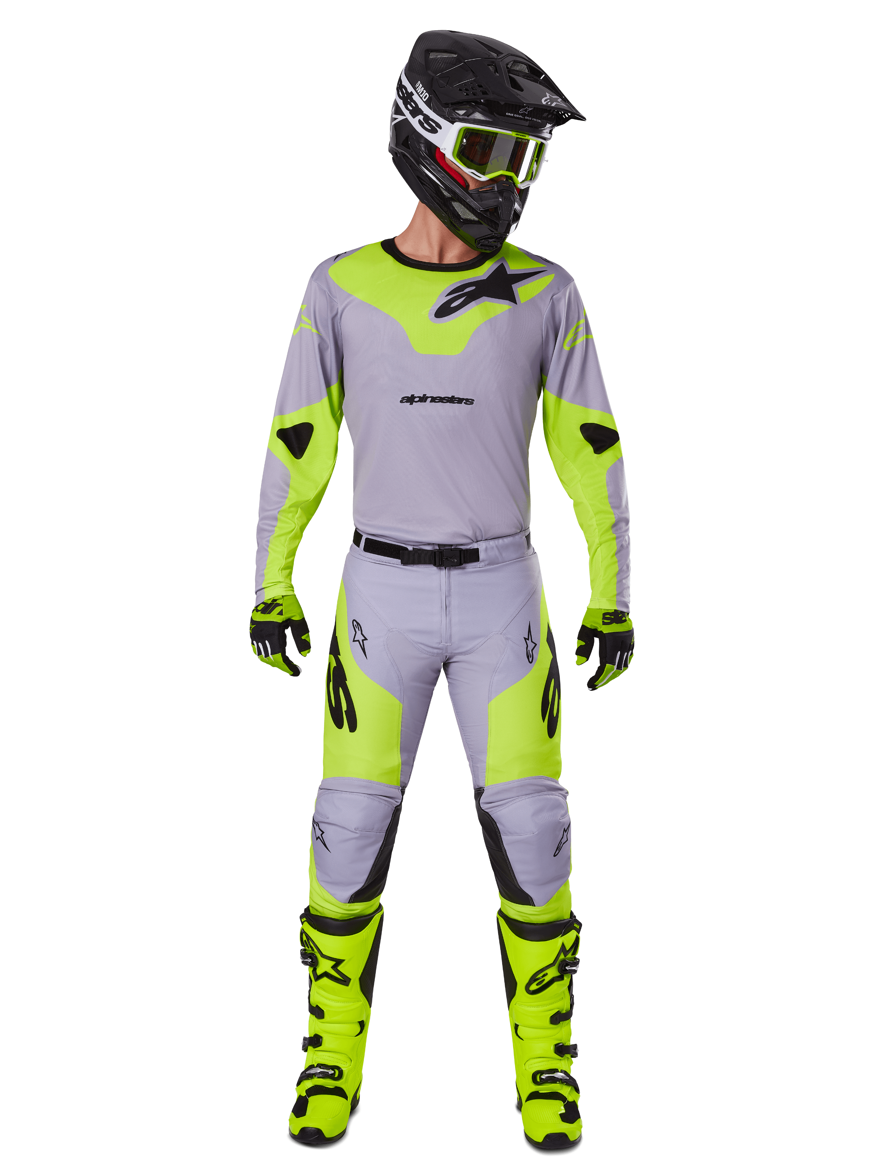 Motocrossrijder in de Alpinestars 2025 Racer Veil Gear Set in grijs en fluogeel, met een lichtgewicht jersey en bijpassende broek, gecombineerd met een zwarte helm, fluo crossbril, handschoenen en felgele laarzen, complete professionele off-road outfit