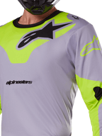 Alpinestars 2025 Racer Veil Jersey, motorcross jersey, grijs en geel fluo, met een groot zwart Astars-logo op de borst, neongele schouder- en mouwpanelen, technische mesh-stof voor off-road racing
