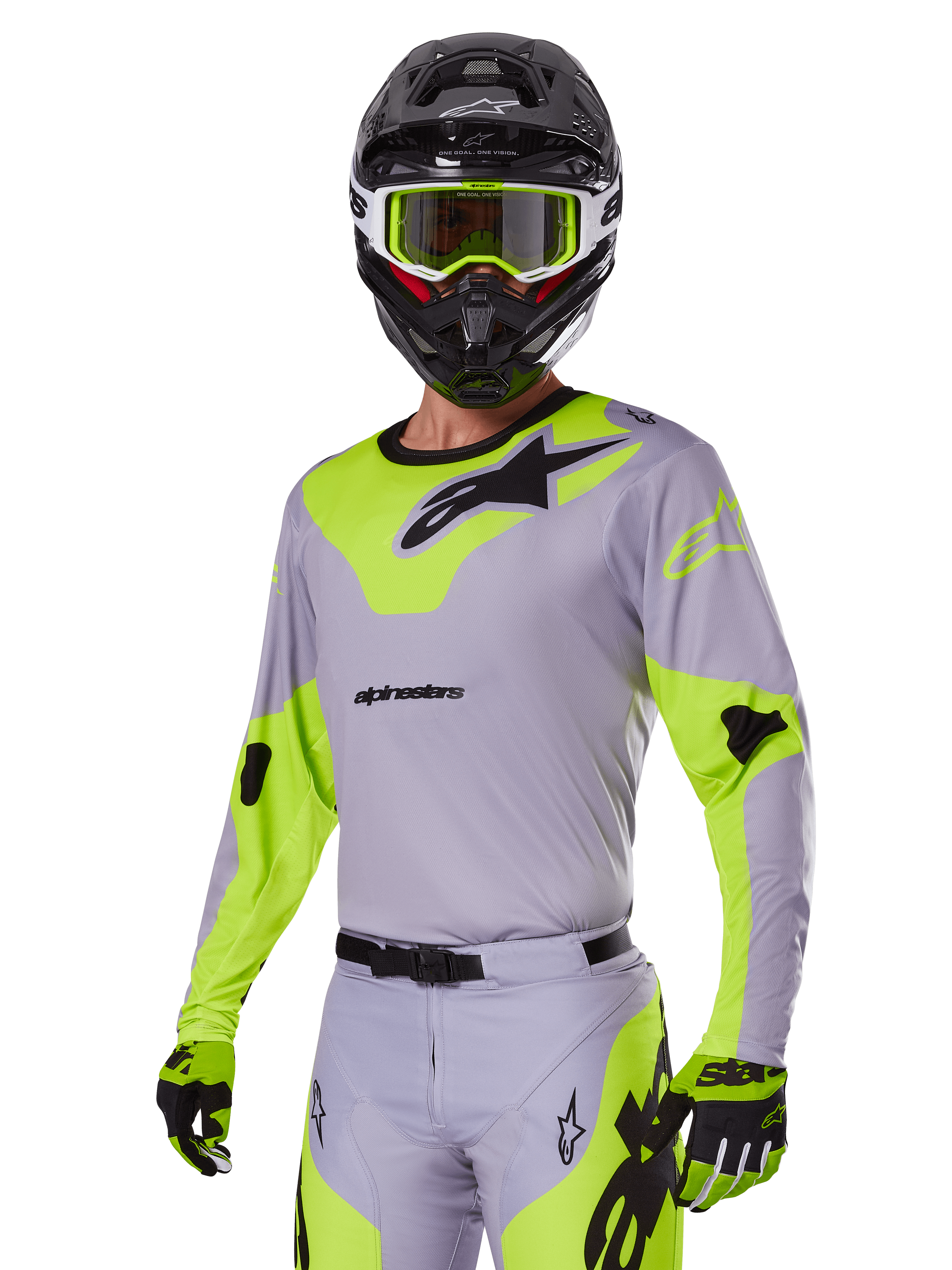 Motorcrosser met Alpinestars 2025 Racer Veil Gear Set in grijs en fluogroen, lichtgrijze jersey en broek met opvallende neongele panelen en zwarte Alpinestars-logo's, bijpassende handschoenen en een zwarte helm met neongroene bril, professionele off-road racekleding