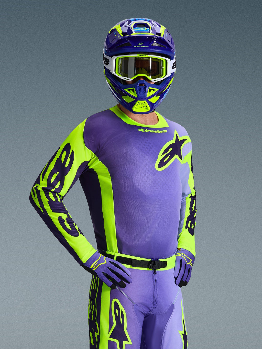 Motocrossrijder in de 2026 Racer Portl Jersey, paars en neon geel, bijpassende paarse en gele helm met witte crossbril, paarse en gele handschoenen, gecoördineerde volledige uitrusting voor off-road racing