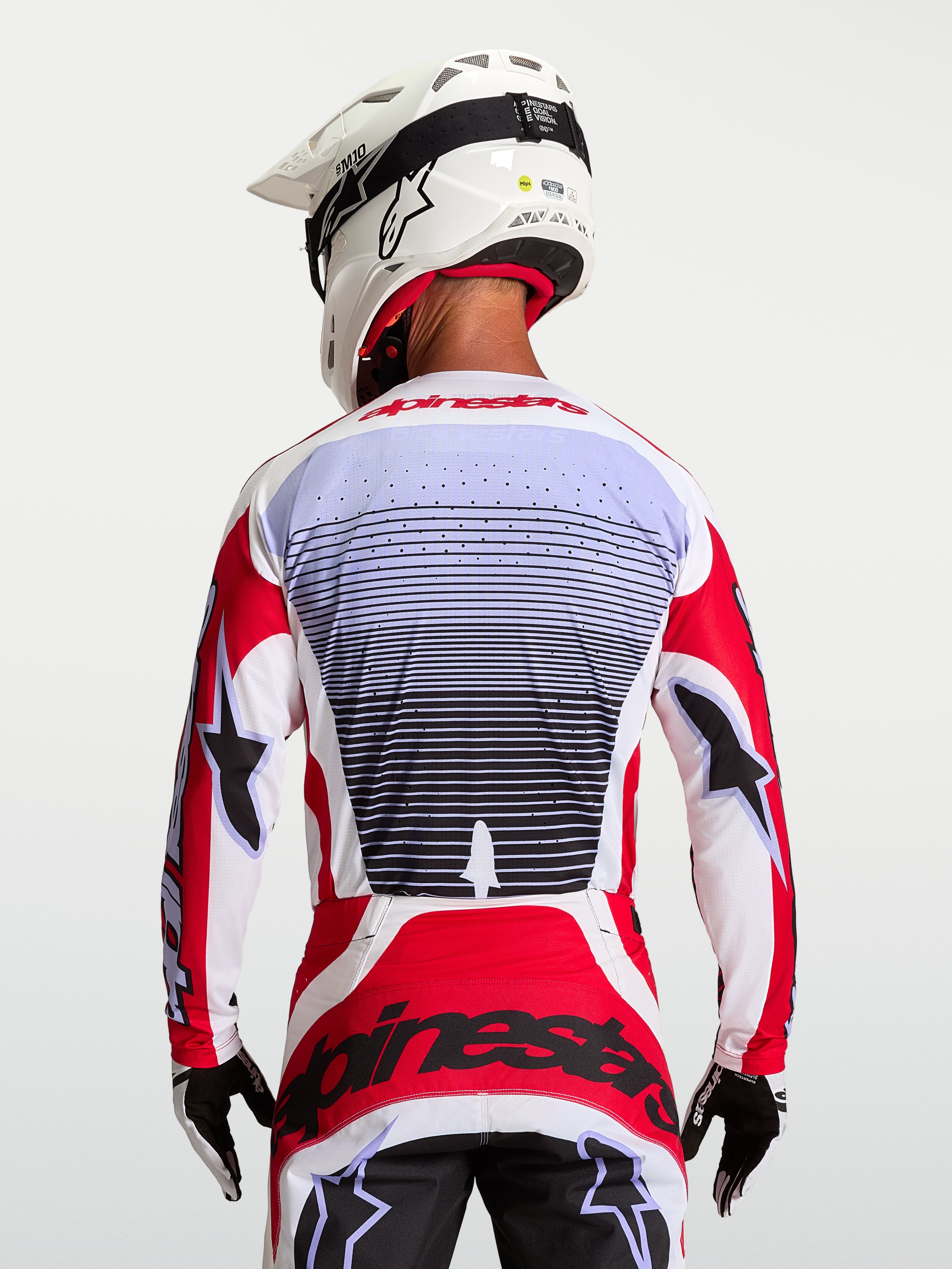 Alpinestars Techstar Maven Jersey, rood en wit ademend motorcrossjersey, achteraanzicht op de rijder.