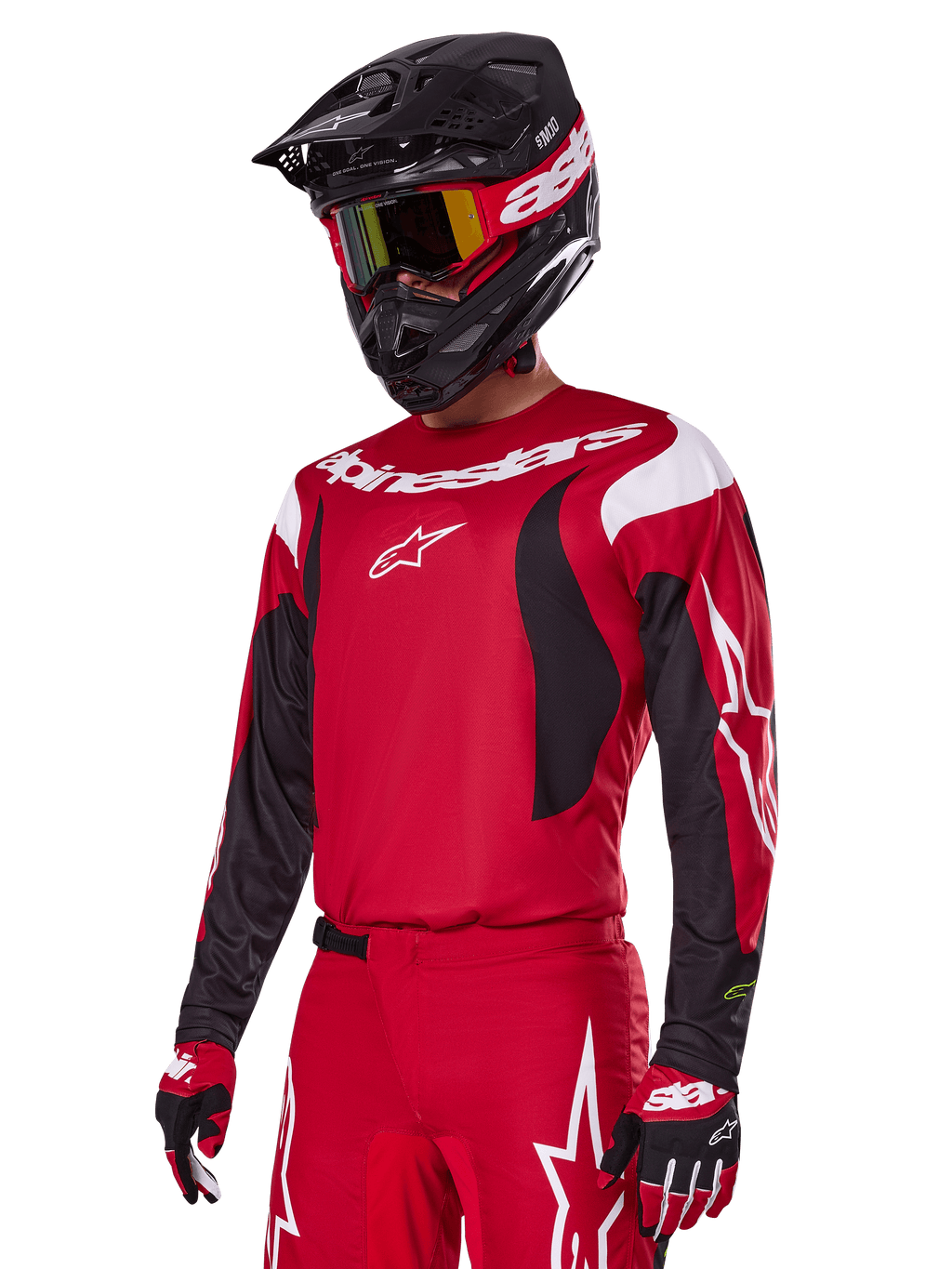 Alpinestars 2025 Fluid Haul Gear Set in het rood, motorcrossrijder in rode jersey met witte en zwarte accenten, bijpassende rode broek met witte graphics, zwarte helm met witte branding, rood-gele crossbril en rood-zwarte handschoenen, gecoördineerde motorcross race-outfit