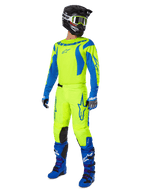 Alpinestars 2025 Fluid Haul motorcrossset, volledige motorcrossuitrusting met neongeel en blauw shirt en broek, zwarte helm, blauwe handschoenen en blauwe off-road laarzen, opvallende gecoördineerde outfit voor motorcross en enduro.